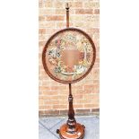 A GOOD EARLY VICTORIAN ROSEWOOD POLESCREEN the circular needlework panel 55cm diameter, 151cm high