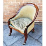 A 19TH CENTURY MAHOGANY FRAMED UPHOLSTERED TUB ARMCHAIR on sabre legs with brass casters, brass ball