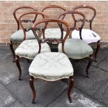 A SET OF SIX VICTORIAN ROSEWOOD BALLOON BACK DINING CHAIRS with carved backrails, serpentine front