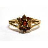 A 9CT GOLD GARNET CLUSTER DRESS RING ring size M, gross weight 2.6 grams. Condition Report :