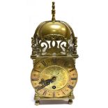 A 20TH CENTURY BRASS LANTERN TYPE CLOCK the chapter ring with roman numerals, 25cm high overall