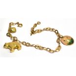 A 14 CARAT GOLD CHARM BRACELET the flat sheet link bracelet with bolt ring fastener containing three
