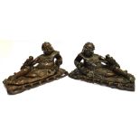 A PAIR OF CHINESE CARVED HARDWOOD GROUPS modelled as reclining figures with mythical beasts inset