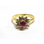 A RUBY AND DIAMOND FLOWER HEAD CLUSTER 18 CARAT GOLD RING the central round cut ruby approx. 4.5mm