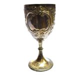A VICTORIAN LARGE SILVER GOBLET on pedestal base with embossed scroll and floral decoration to