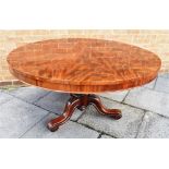 A FIGURED MAHOGANY TILT TOP DINING TABLE, the circular top 129cm diameter, on carved pillar