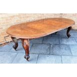 A VICTORIAN EXTENDING MAHOGANY OVAL DINING TABLE with two additional leaves and winder, on carved