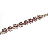 A RUBY SET SILVER BRACELET the central section comprising 8 round clusters of small round cut