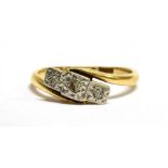 A DIAMOND THREE STONE 18CT GOLD RING three small illusion set diamonds between cross over shoulders,