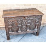 A SMALL CARVED OAK COFFER the lid with chip carving and moulded edge, the front with twin arcaded