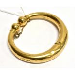 A YELLOW GOLD TORQUE STYLE BANGLE twist design opening, gold ball design to each end, tapering