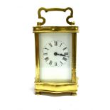 A BRASS CASED CARRIAGE CLOCK the enamel dial with Roman numerals, 13cm high excluding handle