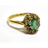 AN EMERALD AND DIAMOND OVAL CLUSTER 18 CARAT GOLD RING central oval cut emerald approx. 7mm x 5mm,