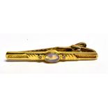AN 18CT GOLD OPAL AND SMALL DIAMOND SET TIE CLIP the central cabochon cut black opal of blue