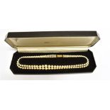 A TWO ROW CULTURED PEARL NECKLACE With a 9 carat gold cushion shaped clasp with radiating pattern,