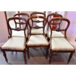 A SET OF SIX VICTORIAN UPHOLSTERED MAHOGANY BALLOON BACK DINING CHAIRS with carved bar backs, on