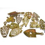 A GROUP OF TWELVE VARIOUS VICTORIAN BRASS TRIVETS