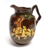 A ROYAL DOULTON BROWN GLAZE JUG with huntsman and hounds in relief beside a tree, height 17cm