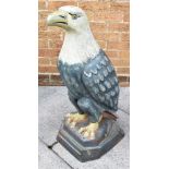 A LARGE CAST AND PAINTED FIGURE OF AN EAGLE on a shaped plinth base, 84cm high, 32cm wide, 40cm