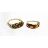TWO GARNET SET DRESS RINGS comprising a boat shaped head with seven cut garnets, ring size T,