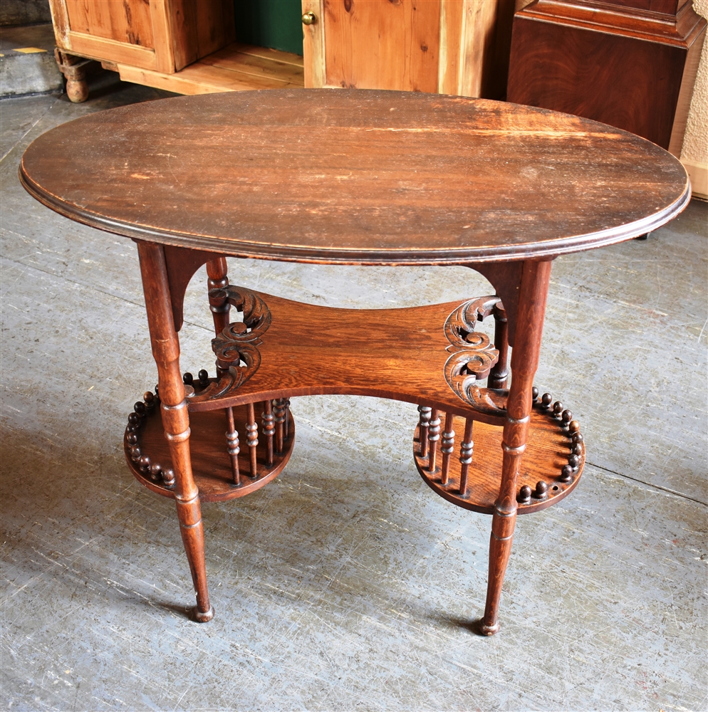 AN EDWARDIAN OAK OCCASIONAL TABLE the oval top 84cm x 45cm, on unusual three tier galleried