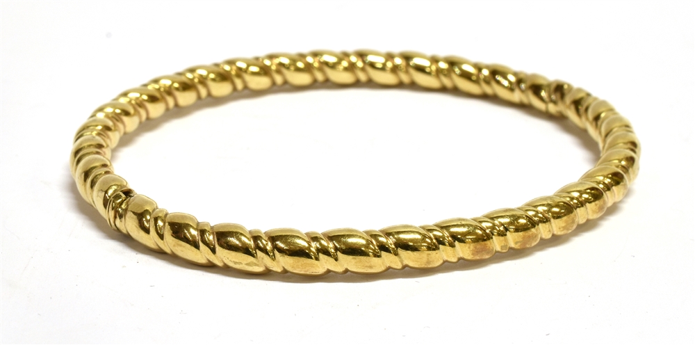 A 9 CARAT GOLD OVAL HINGED BANGLE plain polished barley twist tubular design, tongue snap clasp,