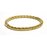 A 9 CARAT GOLD OVAL HINGED BANGLE plain polished barley twist tubular design, tongue snap clasp,