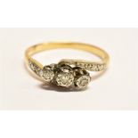 A DIAMOND THREE STONE CROSSOVER 18 CARAT GOLD RING three small illusion set round cut diamonds, ring