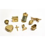NINE ASSORTED 9 CARAT GOLD CHARMS to include a one pound note in cylinder, kangaroo, cuckoo clock