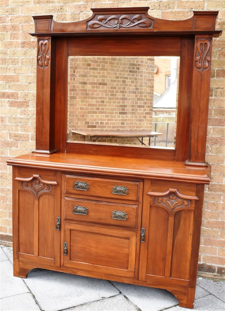 AN EDWARDIAN CARVED MAHOGANY MIRROR BACK SIDEBOARD the base with two central drawers above cupboard,