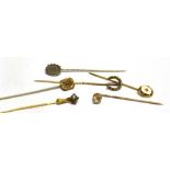A COLLECTION OF SIX STICK PINS comprising a diamond single stone set claw containing a rose cut