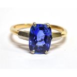 A SAPPHIRE SINGLE STONE GOLD RING the rectangular cushion shaped mixed cut blue sapphire measuring