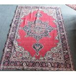 A RED GROUND RUG 131cm x 190cm