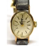 A LADIES 9 CARAT GOLD SMALL OVAL TISSOT WRISTWATCH on a leather strap, the watch 12mm x 20mm,