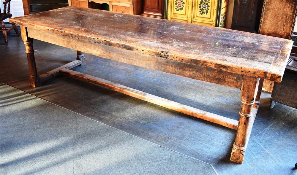 A RUSTIC REFECTORY DINING TABLE the substantial six plank top with cleated ends, on turned