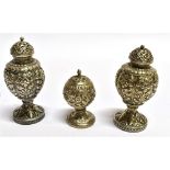 AN ASIAN STYLE WHITE METAL THREE PIECE CONDIMENT SET comprising two pepperettes, one salt,