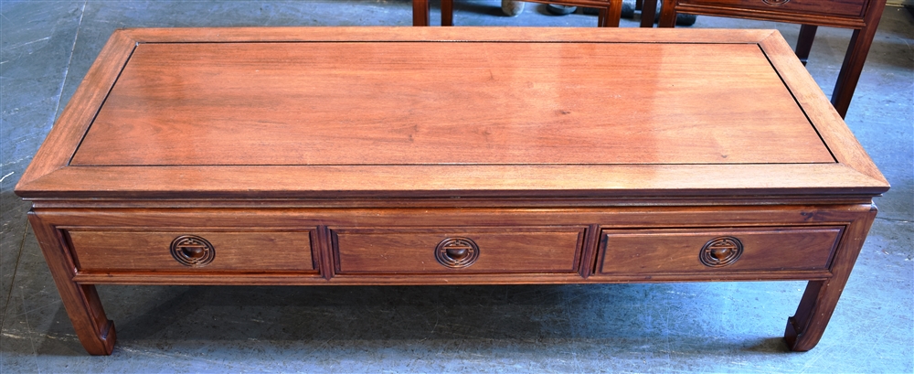 A CHINESE HARDWOOD COFFEE TABLE with three frieze drawers, 53cm x 137cm, 40cm high; together with