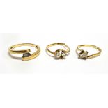 THREE YELLOW GOLD STONE SET CROSSOVER RINGS comprising a blue stone set ring, unmarked, assessed
