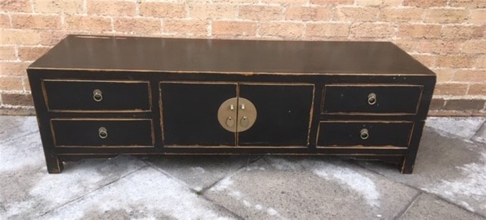 A CHINESE EBONISED LOW SIDEBOARD with central cupboard flanked by pair of drawers to each side,