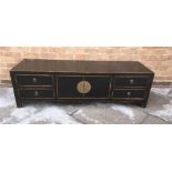 A CHINESE EBONISED LOW SIDEBOARD with central cupboard flanked by pair of drawers to each side,