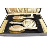 A SIX PIECE SILVER BACKED DRESSING TABLE BOXED SET comprising hand mirror, two hairbrushes, two