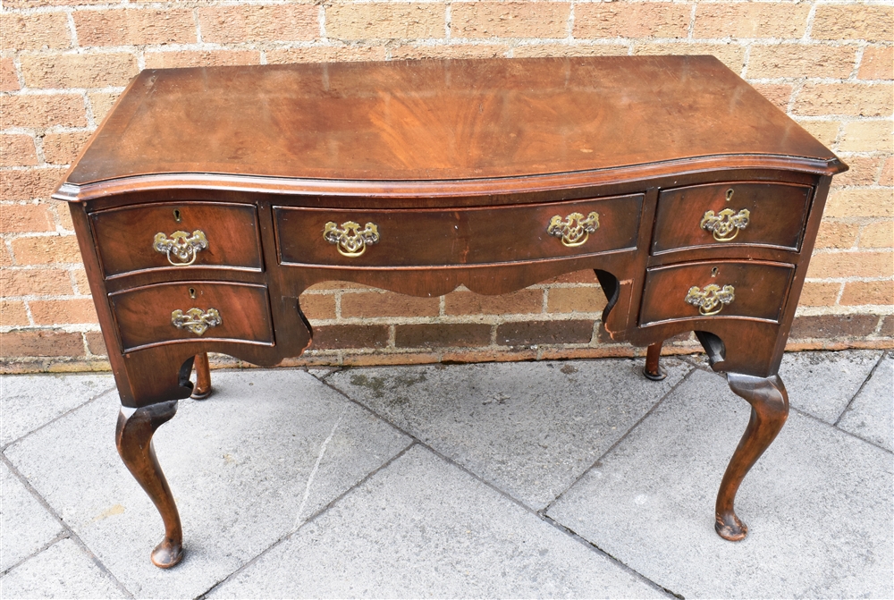 A SERPENTINE FRONT MAHOGANY SIDEBOARD fitted with central drawer flanked by pair of drawers to