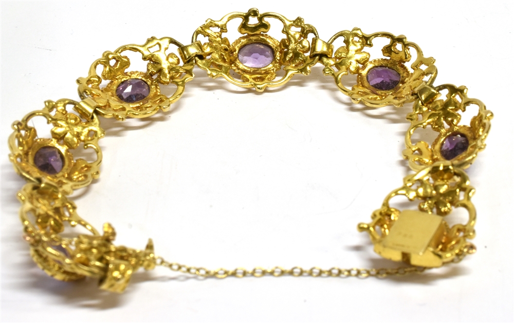 A 9 CARAT GOLD AMETHYST SET BRACELET seven oval openwork links with scroll and flower head - Image 2 of 2