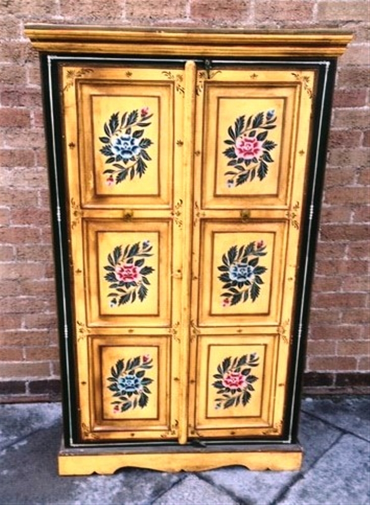 A CONTINENTAL FLORAL PAINTED TWO DOOR CUPBOARD each of the doors with triple panels opening to