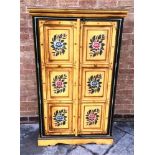 A CONTINENTAL FLORAL PAINTED TWO DOOR CUPBOARD each of the doors with triple panels opening to