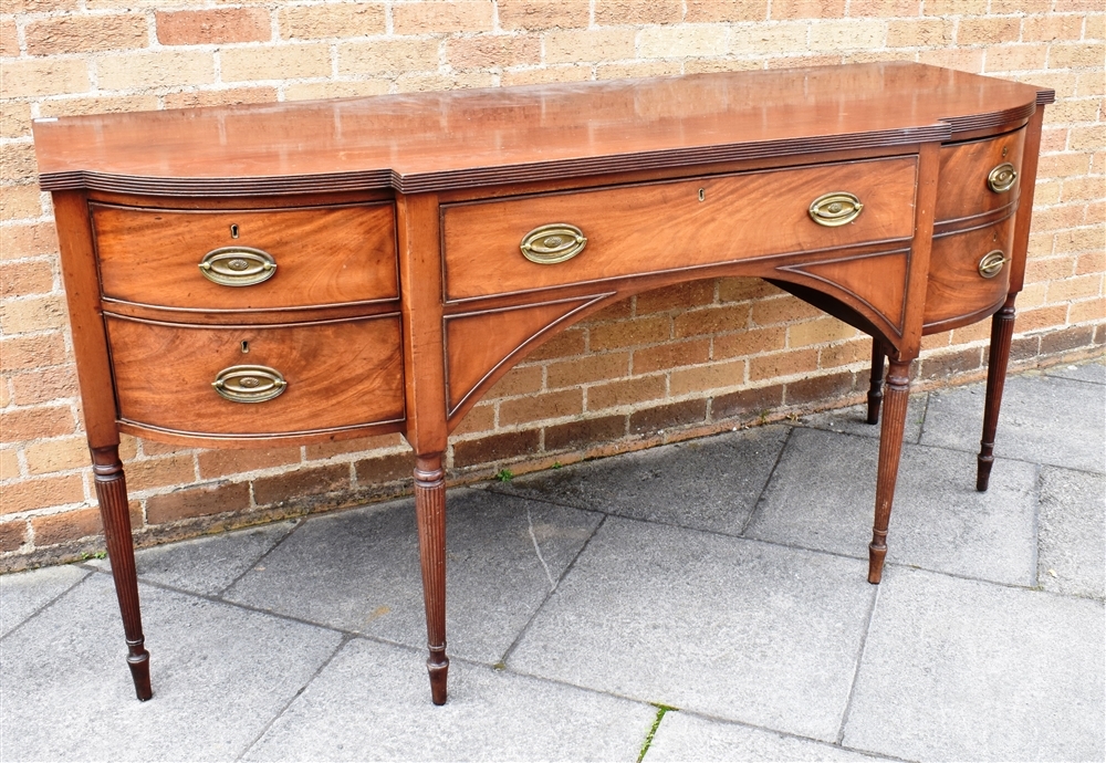 A GEORGE IV MAHOGANY BOWFRONT SIDEBOARD the top with reeded edge, central door flanked by deep