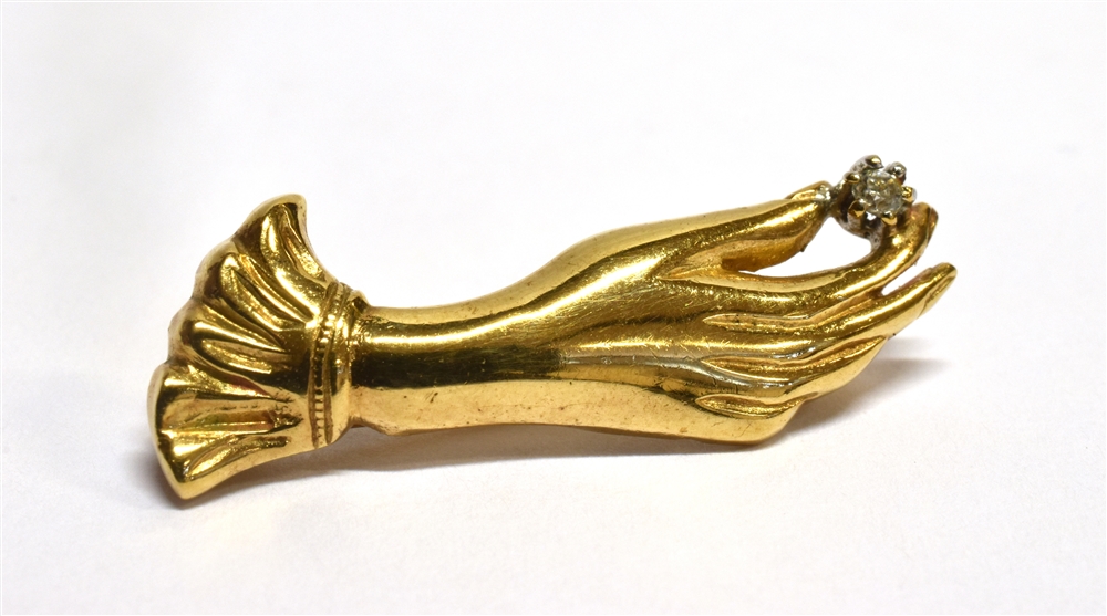 A 9 CARAT GOLD HAND BROOCH set with small white stone, hinge pin and loop fittings, measuring 3cm