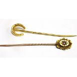 TWO GOLD STICKPINS comprising an 18 carat gold horseshoe and a 15 carat gold small ruby set head,
