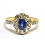 A SAPPHIRE AND DIAMOND OVAL CLUSTER 18CT GOLD RING WITH DIAMOND SET SHOULDERS the central oval mixed