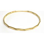 A 9 CARAT GOLD SLAVE BANGLE plain polished with waved borders, measuring 7cm diameter, weighing